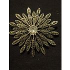 Винтажная брошь-цветок в форме ромашки или хризантемы с темными кристаллами имитирующими марказиты, и крупным светлым кристаллом в центре.