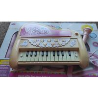 Синтезатор детский в упаковке. В комплекте ножки, микрофон, работает от батареек. очень классный синтезатор, целый, выцвел цвет, ребенок пользовался, любимая игрушка).