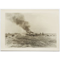 Немецкий обоз проходит мимо советского села и горящей хаты.