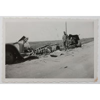 Немецкий солдат у сгоревших советских автомобиля и 76-мм дивизионной пушки образца 1939 года.