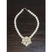 Пластиковое колье с подвеской в форме цветка.