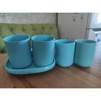 Набор стаканов и полочка в ванную комнату. Цвет бирюзовый. Есть полочка небольшая, которая крепится к стенке клейкой лентой либо на болты (размер 17 на 10 см). Есть 4 стаканчика. Двумя стаканами не по